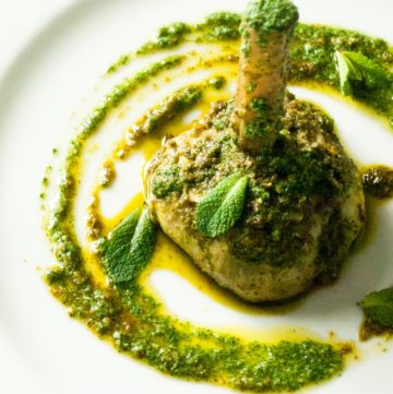 Artichokes with Mint Pesto (carciofi all Romana) – A recipe for whole, braised artichokes, steamed in mint pesto and plenty of fruity olive oil. A speciality of Rome, Italy, that makes an impressive vegetarian appetizer or starter. By @deliciouscratch | deliciousfromscratch.com