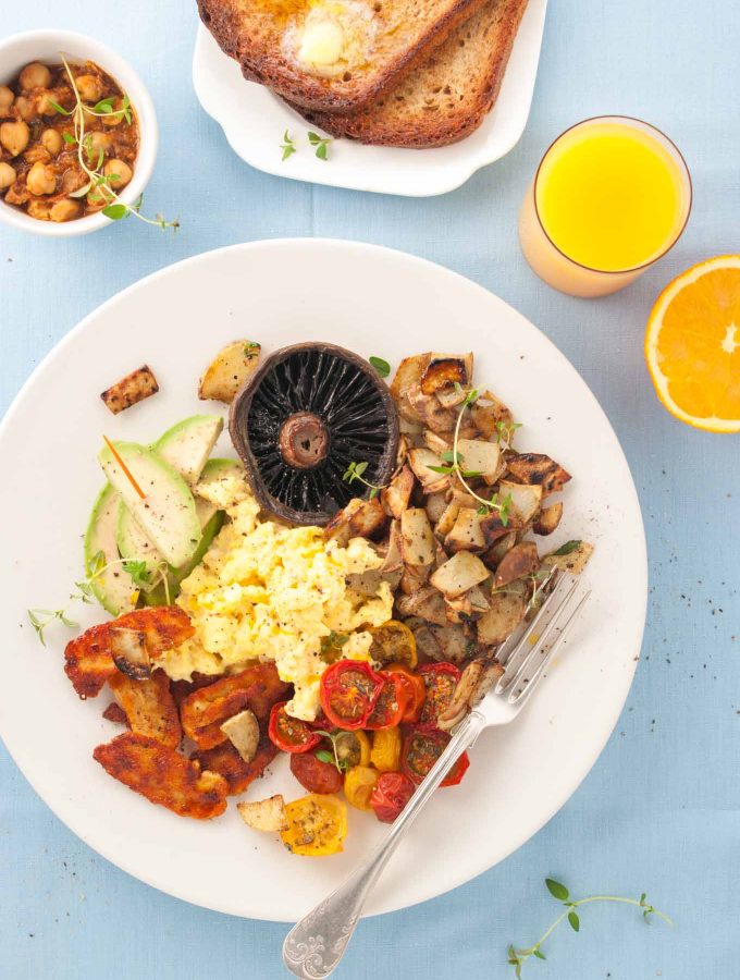 Vegetarian full English breakfast with halloumi bacon from How to Cook Halloumi cookbook by Nancy Anne Harbord. Smoky, marinated halloumi 'bacon', fried potato, roasted tomatoes, avocado, garlic mushroom, creamy scrambled eggs and sourdough toast. The best ever vegetarian full English breakfast! By @deliciouscratch | deliciousfromscratch.com