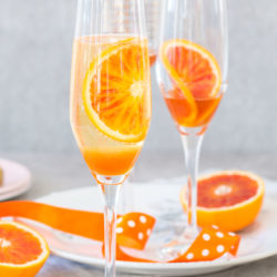 Blood orange fizz cocktail recipe – blood orange syrup, fresh blood oranges and sparkling white wine. The perfect spring cocktail!