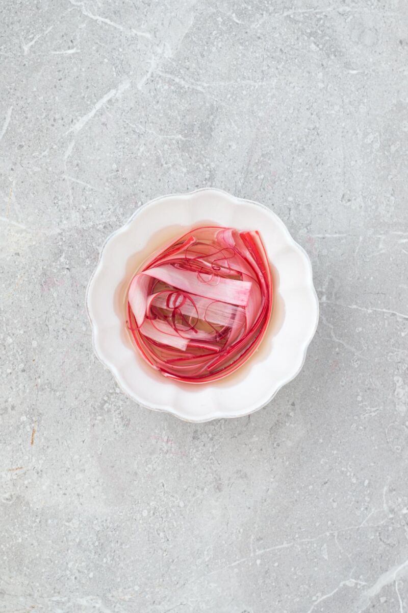A simple, strikingly beautiful rhubarb garnish for cakes, desserts and cocktails. Just soak strips of rhubarb in sugar syrup and dry out in the oven.