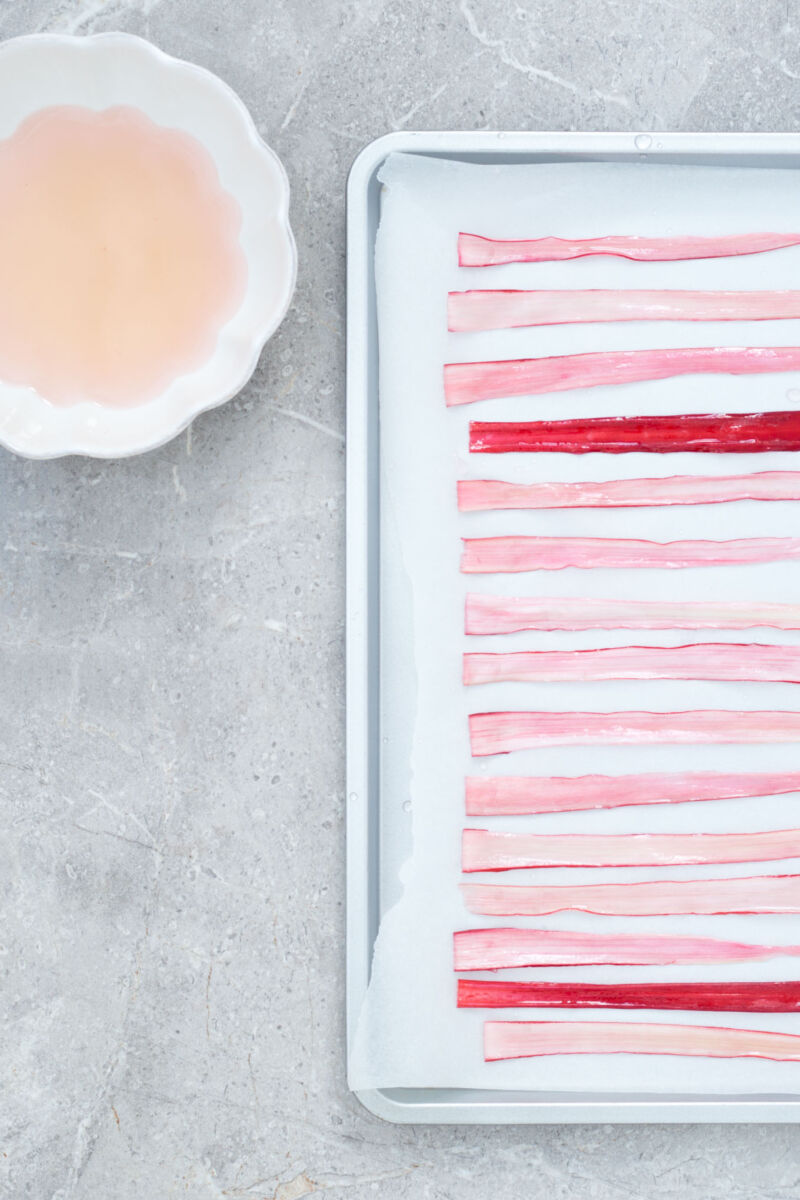 A simple, strikingly beautiful rhubarb garnish for cakes, desserts and cocktails. Just soak strips of rhubarb in sugar syrup and dry out in the oven.
