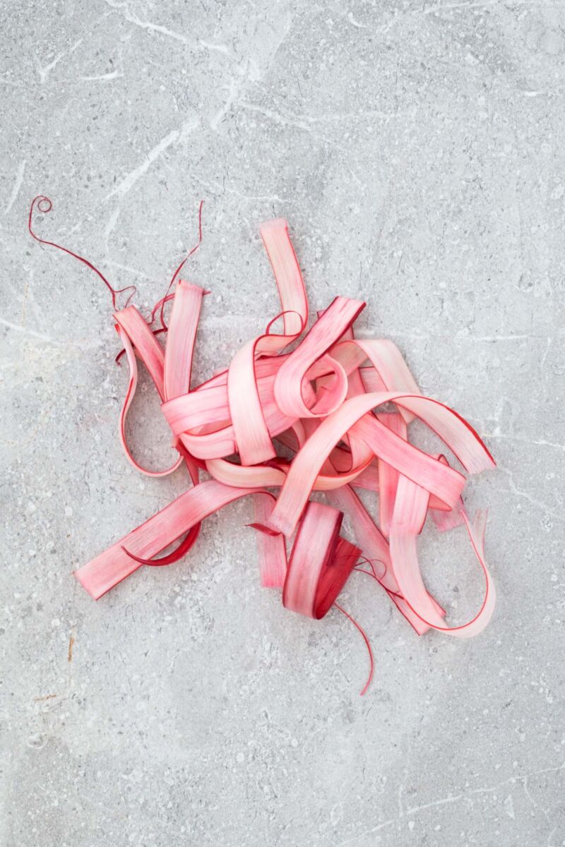 A simple, strikingly beautiful rhubarb garnish for cakes, desserts and cocktails. Just soak strips of rhubarb in sugar syrup and dry out in the oven.